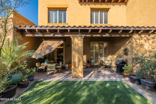 rear view of property featuring a yard and a patio area