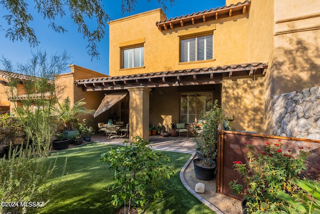 rear view of property featuring a patio area and a yard