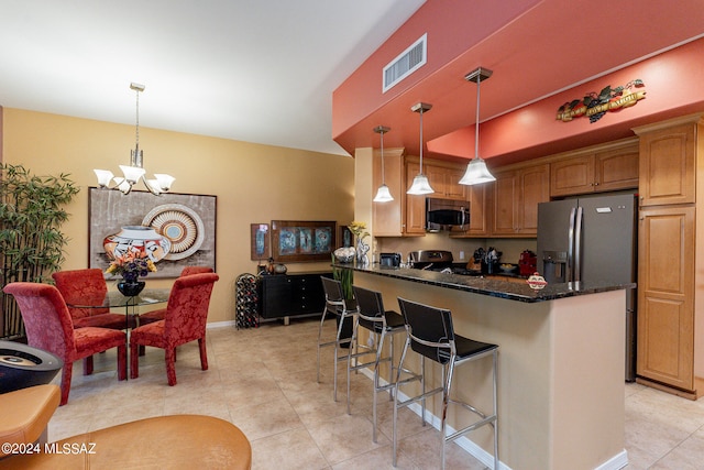 kitchen featuring pendant lighting, a notable chandelier, a breakfast bar, and appliances with stainless steel finishes