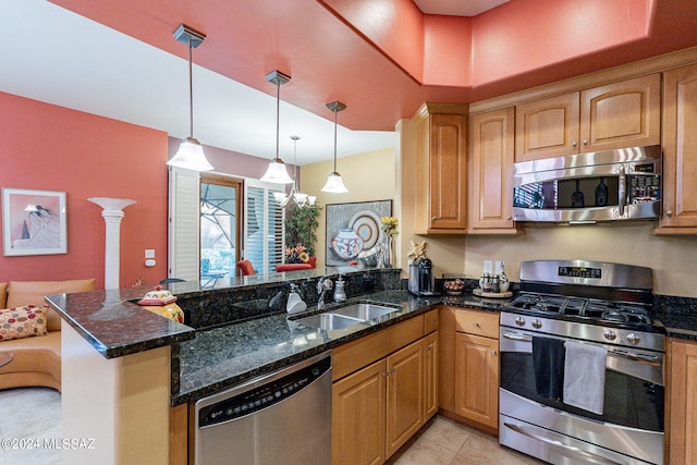 kitchen featuring kitchen peninsula, dark stone countertops, sink, and stainless steel appliances