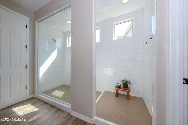 9745 S Desert Flint Dr, Tucson, AZ 85747 - interior space with plenty of natural light, tile walls, tiled shower, and wood finished floors