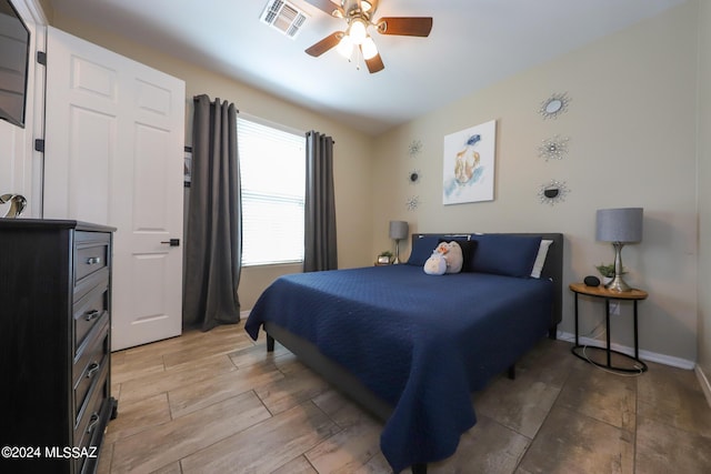 9745 S Desert Flint Dr, Tucson, AZ 85747 - bedroom featuring ceiling fan, baseboards, light wood-style floors, and visible vents