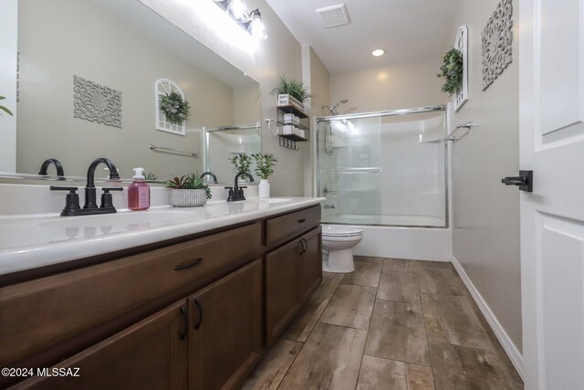 9745 S Desert Flint Dr, Tucson, AZ 85747 - full bathroom with toilet, a sink, double vanity, and combined bath / shower with glass door