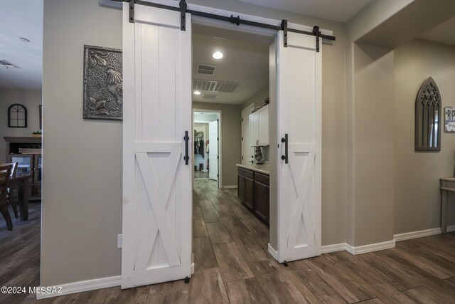 9745 S Desert Flint Dr, Tucson, AZ 85747 - hall featuring baseboards, visible vents, dark wood-type flooring, and a barn door