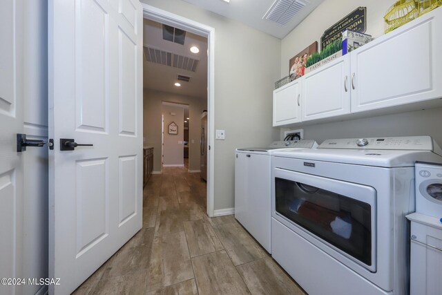 9745 S Desert Flint Dr, Tucson, AZ 85747 - washroom featuring washing machine and dryer, visible vents, recessed lighting, and cabinet space