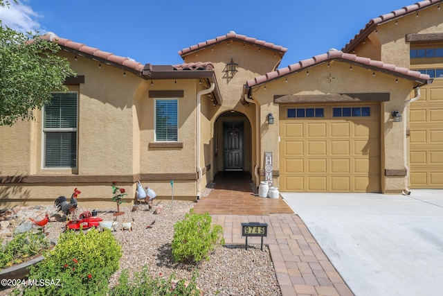 9745 S Desert Flint Dr, Tucson, AZ 85747 - mediterranean / spanish home featuring an attached garage, a tile roof, driveway, and stucco siding