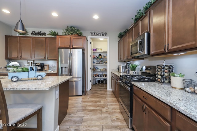 9745 S Desert Flint Dr, Tucson, AZ 85747 - kitchen with light stone countertops, recessed lighting, appliances with stainless steel finishes, and hanging light fixtures