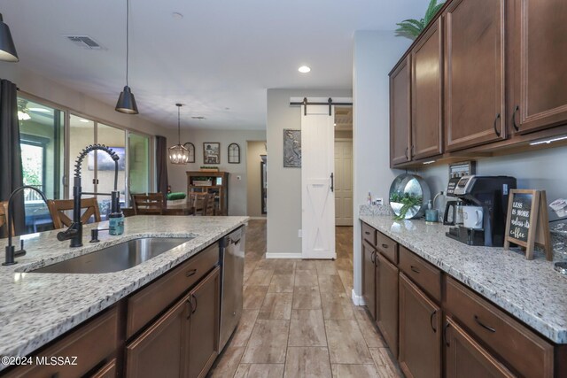 9745 S Desert Flint Dr, Tucson, AZ 85747 - kitchen featuring stainless steel dishwasher, a sink, a barn door, visible vents, and pendant lighting