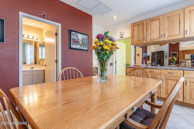 dining space featuring sink and light tile patterned floors