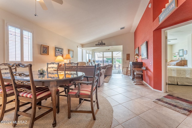 tiled dining space featuring ceiling fan and lofted ceiling