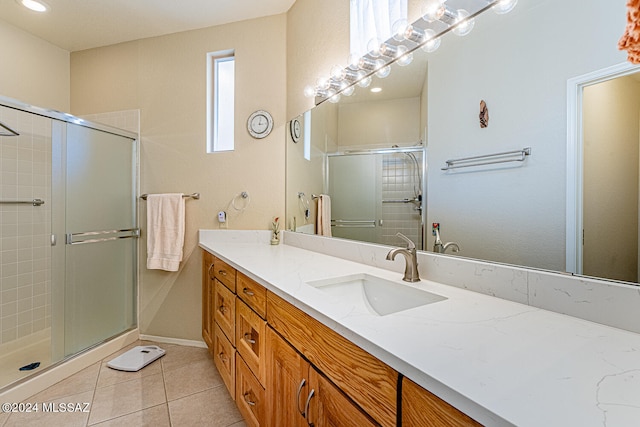 bathroom with tile patterned floors, walk in shower, and vanity