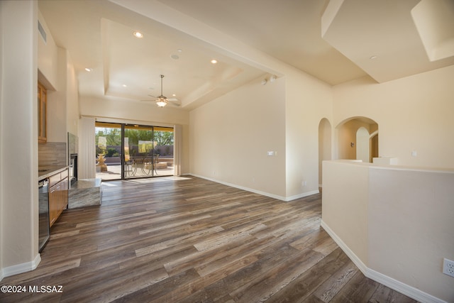 living room featuring ceiling fan, beverage cooler, a raised ceiling, and dark wood-type flooring