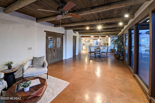 living room featuring concrete flooring, ceiling fan, beamed ceiling, and wooden ceiling