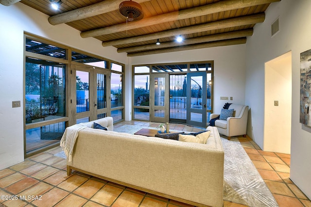 living room with beamed ceiling, french doors, light tile patterned floors, and wood ceiling