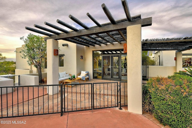 patio terrace at dusk featuring outdoor lounge area and a pergola