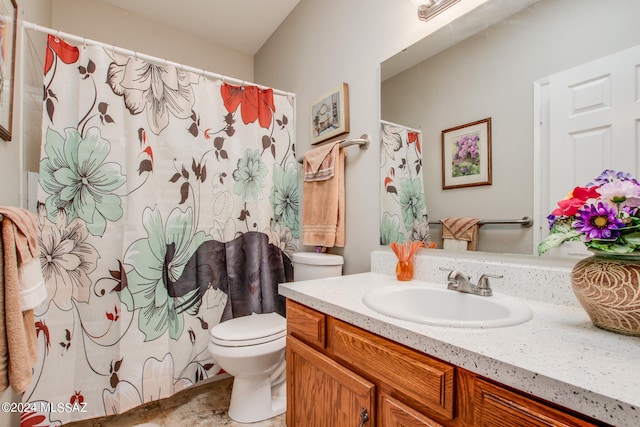 bathroom featuring walk in shower, vanity, and toilet