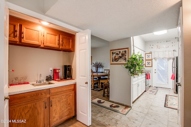 kitchen featuring a textured ceiling and sink