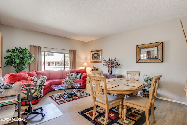 dining area with a textured ceiling and hardwood / wood-style flooring