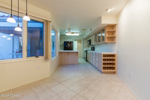 kitchen featuring a wealth of natural light, black appliances, decorative light fixtures, and ceiling fan