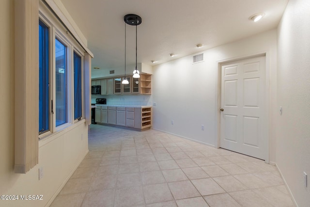 kitchen featuring electric stove, light tile patterned floors, and hanging light fixtures