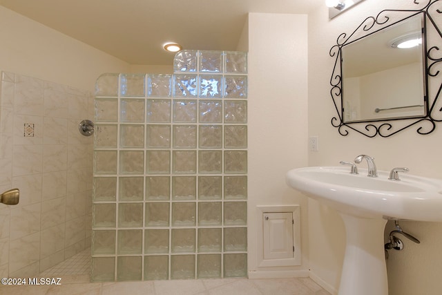 bathroom featuring a tile shower, sink, and tile patterned floors