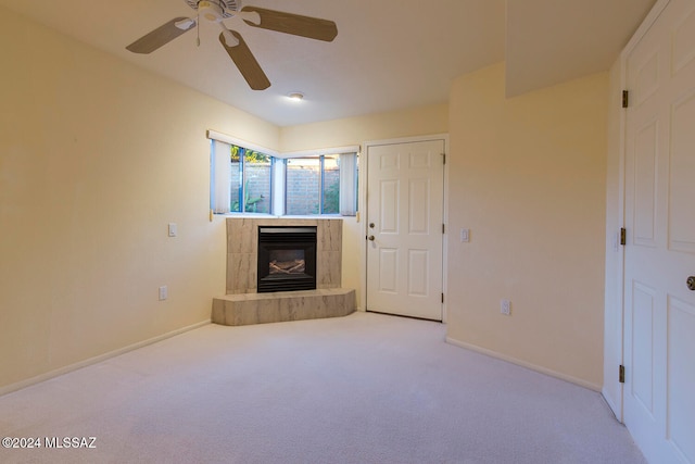 unfurnished living room with light carpet, a tile fireplace, and ceiling fan