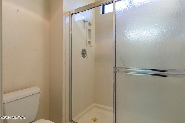 bathroom with toilet and an enclosed shower