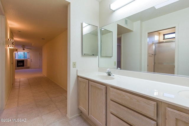 bathroom with vanity, walk in shower, tile patterned floors, and a fireplace