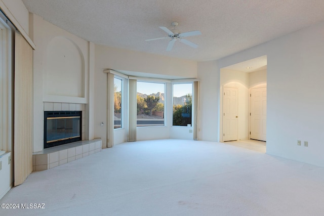 living room featuring light colored carpet, a textured ceiling, and a fireplace