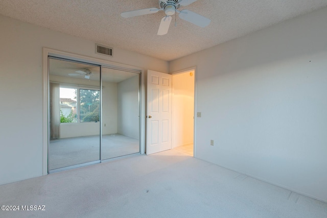 unfurnished bedroom with a closet, a textured ceiling, and ceiling fan