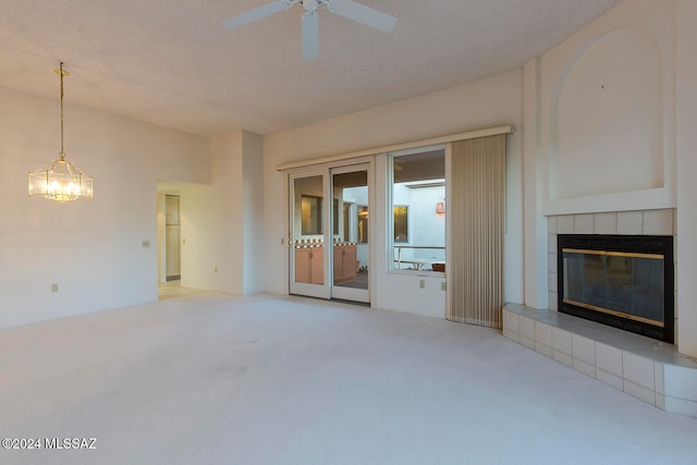 unfurnished living room with carpet, a fireplace, a textured ceiling, and ceiling fan