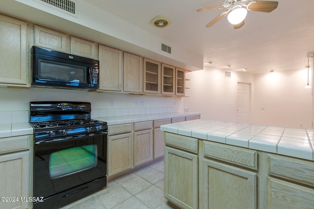 kitchen featuring light brown cabinets, tile countertops, black appliances, light tile patterned floors, and ceiling fan