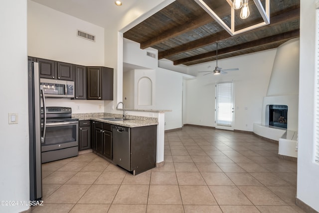 kitchen featuring appliances with stainless steel finishes, beamed ceiling, light tile patterned floors, wooden ceiling, and sink