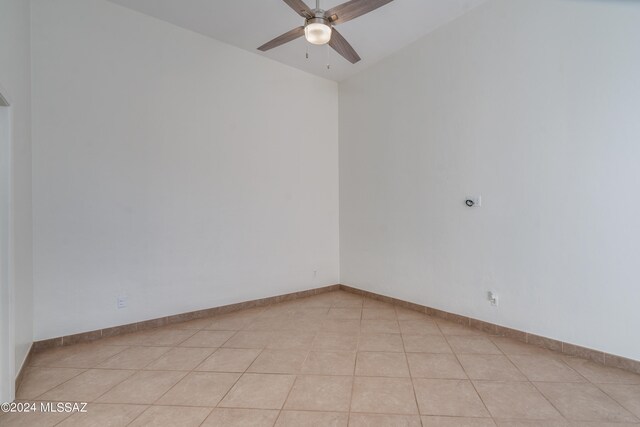 unfurnished room featuring vaulted ceiling, ceiling fan, and light tile patterned floors