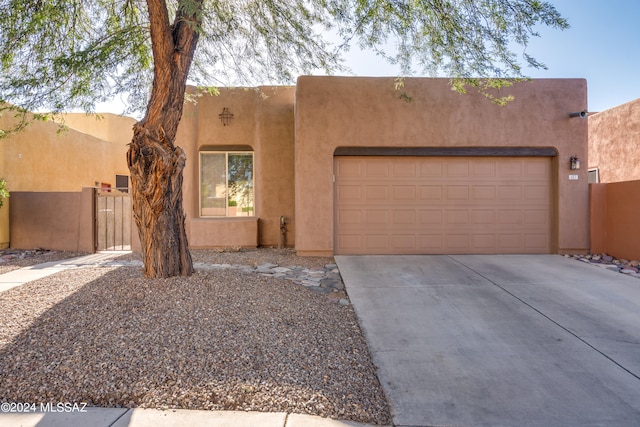 pueblo revival-style home featuring a garage