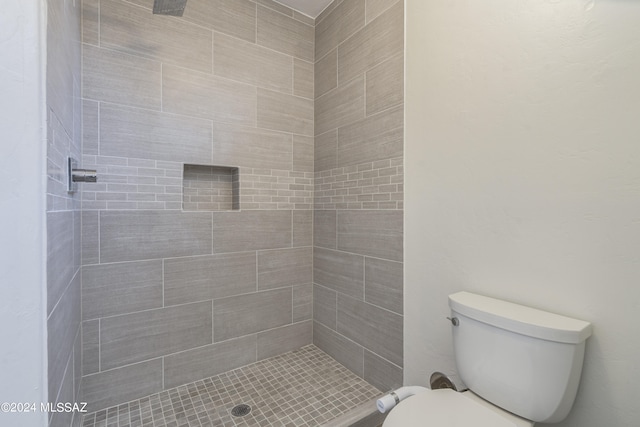 bathroom featuring toilet and tiled shower