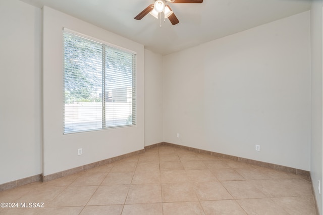 tiled spare room featuring ceiling fan