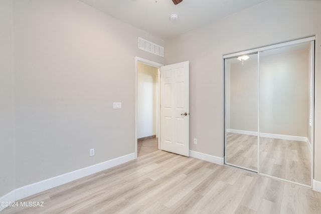 unfurnished bedroom featuring ceiling fan, a closet, and light hardwood / wood-style floors