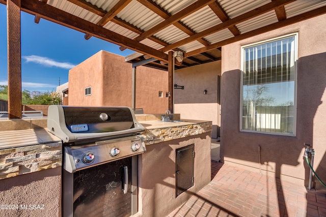 view of patio / terrace featuring area for grilling, sink, and an outdoor kitchen