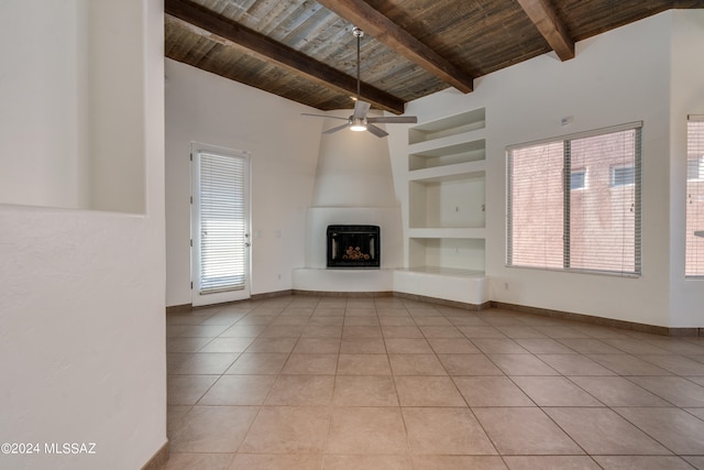 unfurnished living room featuring built in shelves, ceiling fan, light tile patterned flooring, wooden ceiling, and a large fireplace