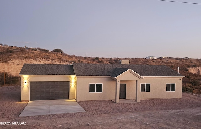 view of front of home featuring concrete driveway, an attached garage, and stucco siding