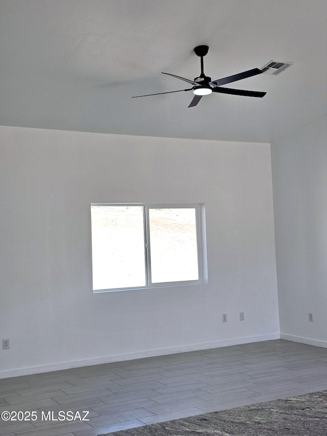 unfurnished room with baseboards, visible vents, and ceiling fan