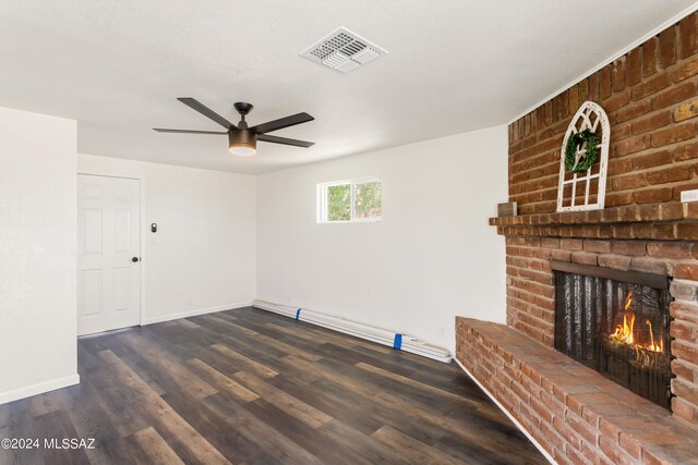 unfurnished living room featuring ceiling fan, a brick fireplace, a baseboard heating unit, and dark hardwood / wood-style flooring