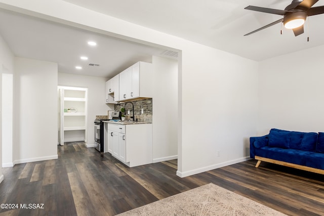 interior space with backsplash, stainless steel stove, white cabinets, light stone counters, and dark hardwood / wood-style flooring