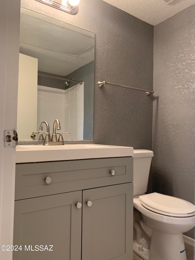 bathroom with a shower, vanity, and toilet