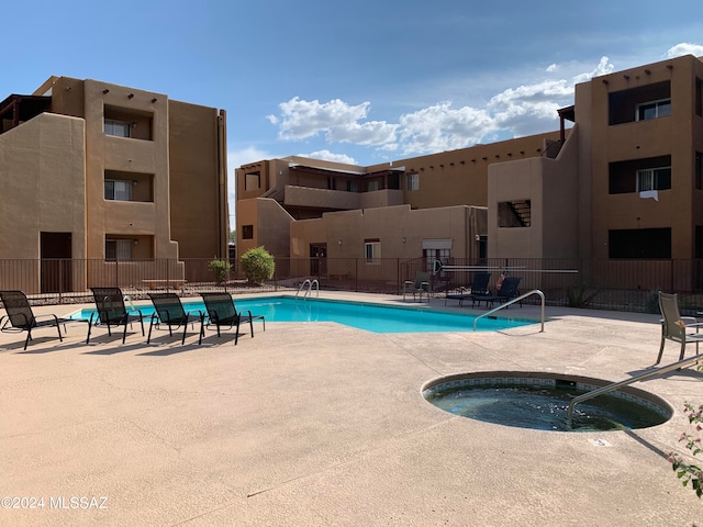 view of pool with a hot tub and a patio