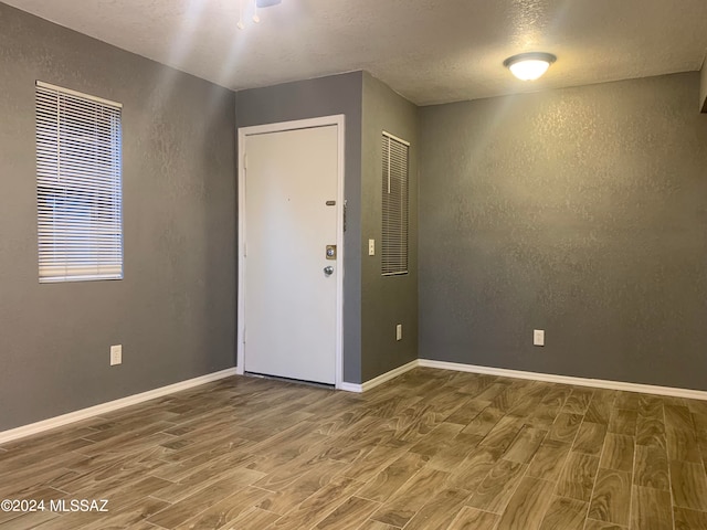 empty room with a textured ceiling and hardwood / wood-style flooring