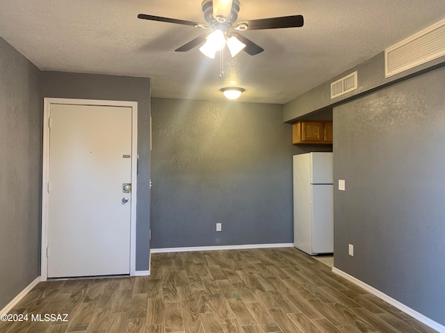 spare room featuring ceiling fan, a textured ceiling, and dark wood-type flooring