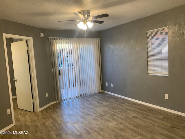 unfurnished room with wood-type flooring, ceiling fan, and a textured ceiling