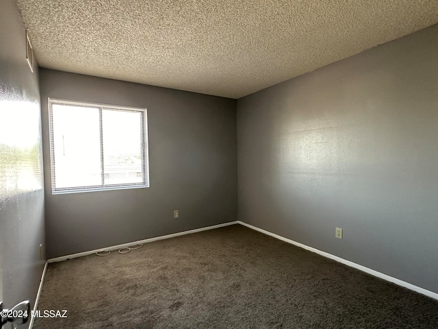 spare room with a textured ceiling and carpet flooring